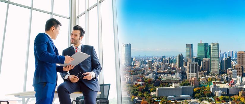 Two business people talk project strategy at office in widen view meeting room. Businessman discuss project planning with colleague at modern workplace .