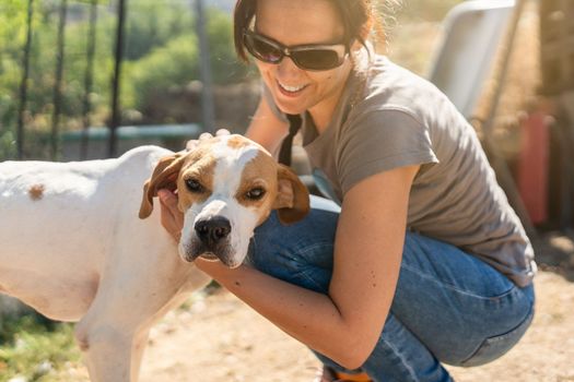 Portrait of a woman petting a dog in a rural house