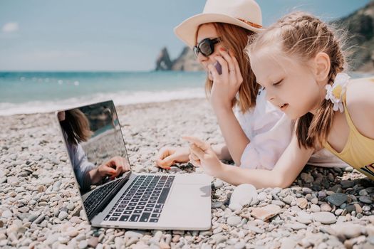 Woman sea laptop. Business woman in yellow hat working on laptop by sea. Close up on hands of pretty lady typing on computer outdoors summer day. Freelance, digital nomad, travel and holidays concept.
