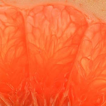 Grapefruit close-up. Slice of blood red ripe grapefruit. Texture of red juicy grapefruit. Macro horizontal image.