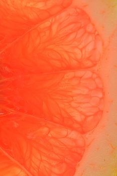 Grapefruit close-up. Slice of blood red ripe grapefruit. Texture of red juicy grapefruit. Macro vertical image.
