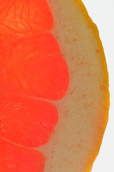Fresh organic grapefruit slice on white background. Grapefruit close-up. Slice of blood red ripe grapefruit. Texture of red juicy grapefruit. Macro verical image.