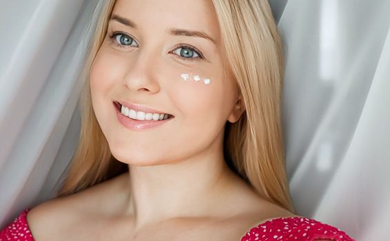 Beautiful woman with skincare cream on her face.