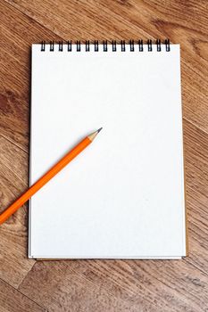 Notebook and pencils on a wooden table, copy space