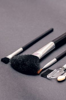 Makeup brushes on a purple background close up