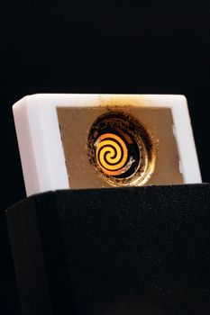 Ectronic lighter with a spiral close up on black background
