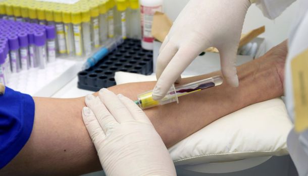 A nurse in a laboratory takes a blood test from a patient