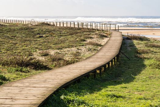 Wooden footpath through the dunes to the beach of praia de Silvalde , Portugal.