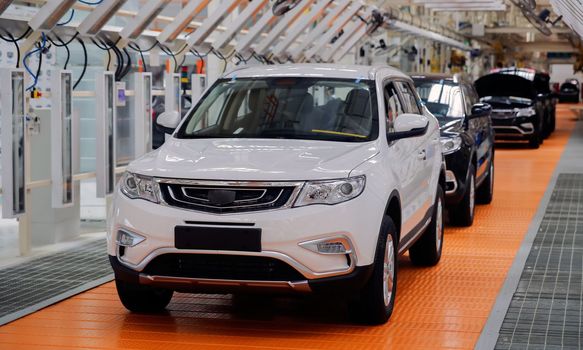 Factory for the production of cars, factory conveyor. Cars are being assembled.