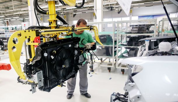 Factory for the production of cars, factory conveyor. Cars are being assembled.