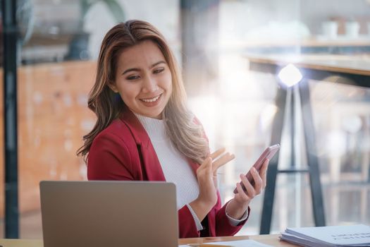 Portrait of Smiling asian business woman with laptop computer in office. Woman in suit at office.