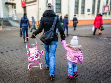 sale, consumerism and people concept - happy mother and child with shopping bags walking along city street