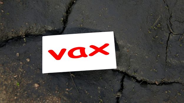 Vaccination or no vaccine, decision to vaccinate or not vaccinate against Covid-19 Coronavirus epidemic. Card with an inscription on a background of black earth and cracks.
