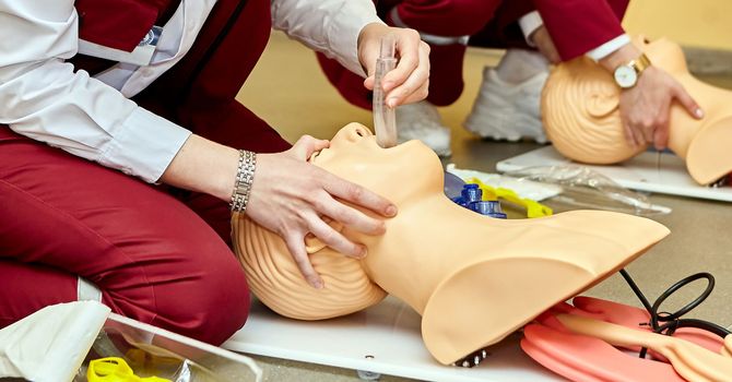 CPR first aid resuscitation adult man life size training dummy model, doll face closeup, detail, mannequin mouth wide open, medical equipment. Paramedic class training simple props abstract concept