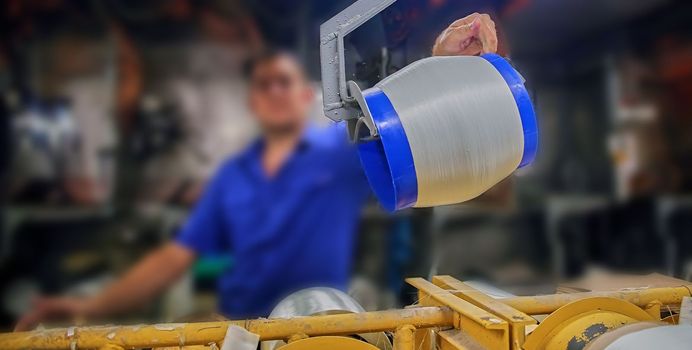 Woven fiberglass roving in a soft cockpit. Fiberglass spools in the workshop.