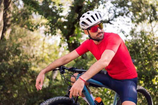 young cyclist resting during his mountain bike training ride, concept of freedom and sport in nature