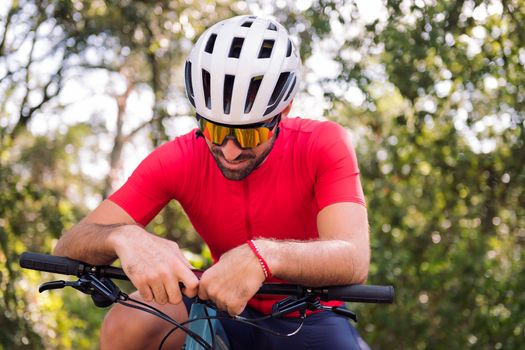young cyclist loading the route on his mountain bike navigator to go for a training ride, concept of freedom and sport in nature