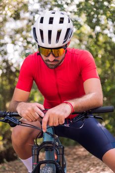 young cyclist loading the route on his mountain bike navigator to go for a training ride, concept of freedom and sport in nature