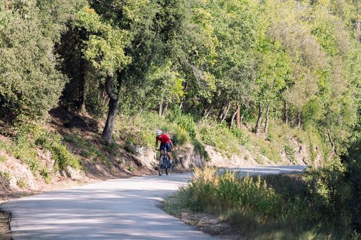 young cyclist training hard with his mountain bike on a forest road, concept of freedom and sport in nature, copy space for text