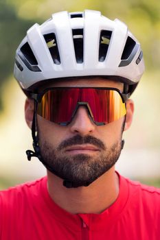portrait of a young cyclist wearing a helmet and cycling goggles looking at camera with a defiant attitude