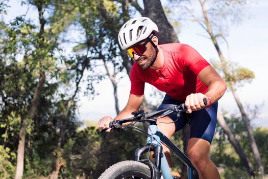young cyclist training hard in the bush with his mountain bike, concept of freedom and sport in nature, copy space for text