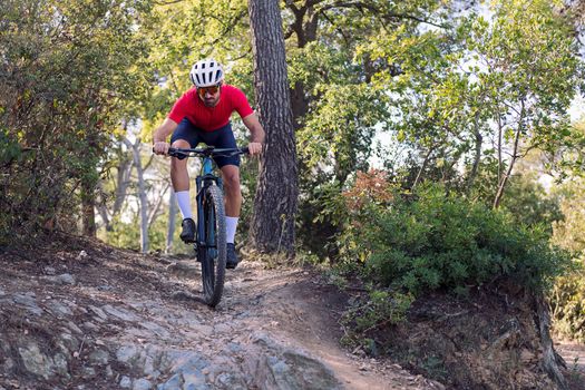 young cyclist descending on a technical trail on his mountain bike, concept of freedom and sport in nature