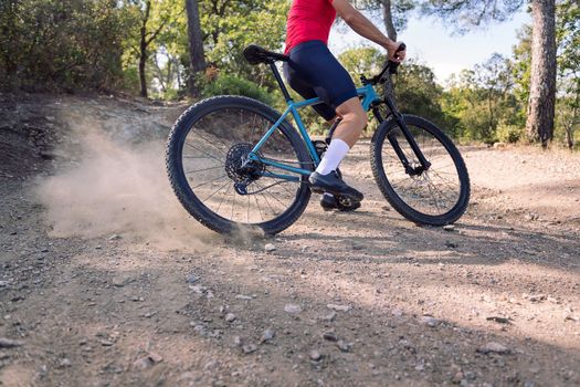 legs of an unrecognizable cyclist drifting, on his mountain bike, concept of freedom and sport in nature, copy space for text