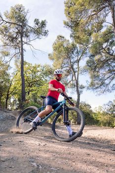 young cyclist drifting with his mountain bike, concept of freedom and sport in nature, copy space for text