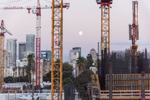 TEL AVIV, ISRAEL - MAY 01 2022: Somail complex in Tel Aviv in the evening with the moon rising. Construction work on the new Tel Aviv Municipality building. Ibn Gvirol Urban Renewals. High quality photo