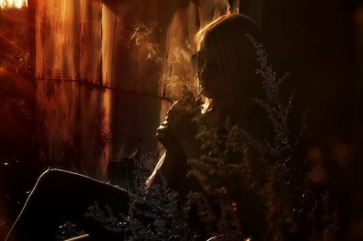 Fashion art portrait of beauty model woman in bright lights with colorful smoke. Smoking girl, Close up of a female inhaling from an electronic cigarette. High quality photo