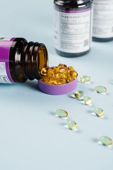 BADS Capsules of Omega-3 biologically active dietary supplements in plastic jar close-up. Vitamin D for building and maintaining healthy bones