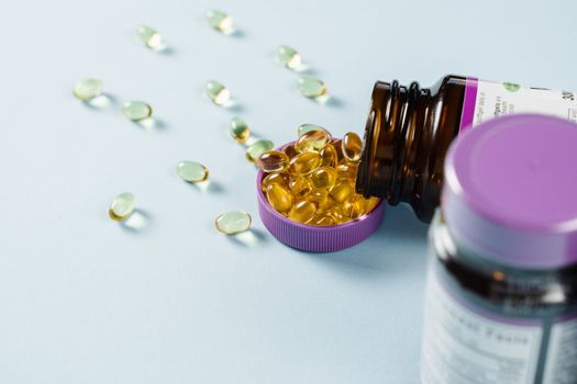 BADS Capsules of Omega-3 biologically active dietary supplements in plastic jar close-up. Vitamin D for building and maintaining healthy bones