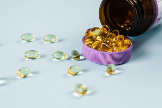 BADS Capsules of Omega-3 biologically active dietary supplements in plastic jar close-up. Vitamin D for building and maintaining healthy bones