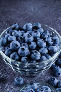 Blueberries organic natural berry on dark background. Blueberry in glass bowl plate