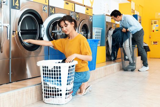 Asian people using qualified coin operated laundry machine in the public room to wash their cloths. Concept of a self service commercial laundry and drying machine in a public room.