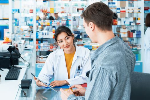 Payment by credit card with payment terminal in qualified drugstore. Modern financial payment of electric money. Caucasian customer purchase medication in pharmacy with prescription from pharmacist.