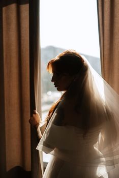 portrait of a bride girl with red hair in a white wedding dress with a bouquet