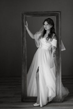 portrait of a bride girl with red hair in a white wedding dress with a bouquet