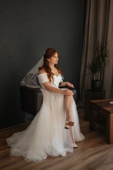 portrait of a bride girl with red hair in a white wedding dress with a bouquet