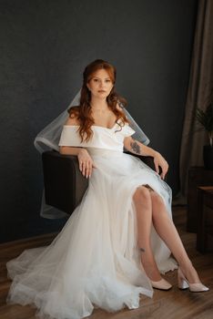 portrait of a bride girl with red hair in a white wedding dress with a bouquet
