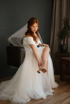 portrait of a bride girl with red hair in a white wedding dress with a bouquet