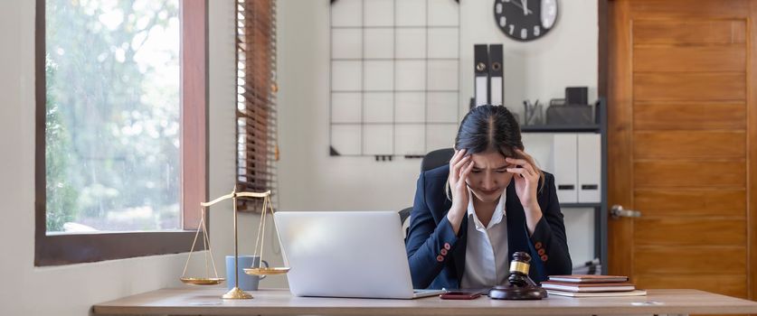 A young businesswoman lawyer is looking stressed as she works at her computer. consultant lawyer, justice and law ,attorney, court judge, concept.