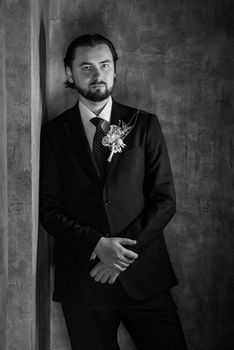 portrait of a male groom in a blue suit in the morning going to the barbershop on the wedding day