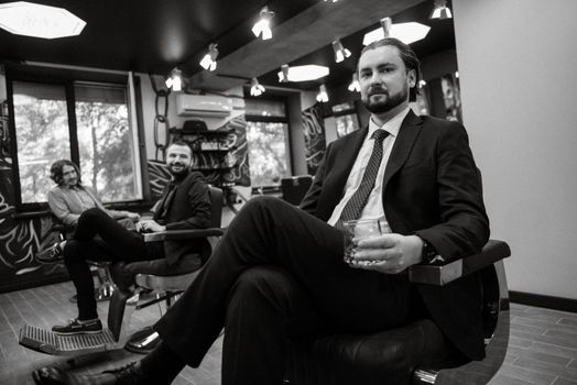 portrait of a male groom in a blue suit in the morning going to the barbershop on the wedding day