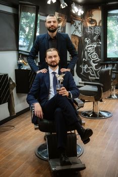 portrait of a male groom in a blue suit in the morning going to the barbershop on the wedding day