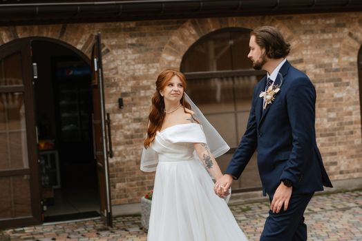 young couple bride and groom in a white dress walking