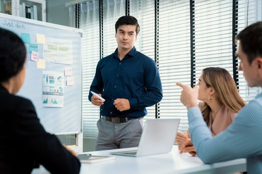 Competent office workers from various nationalities are debating, discussing and brainstorming in the meeting room. A group of employees is collaborating to achieve their business objectives.