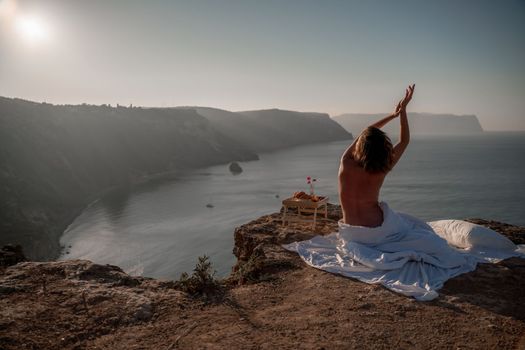 Woman wake up in bed wuth duvet and pillow over nature sea background outdoors. Back view. Good morning. Freedom concept