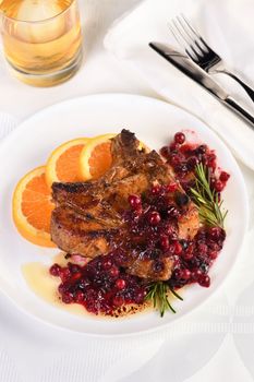 Fried pork chops served with cranberry sauce with orange and rosemary. They are elegant for a lunch or dinner party.