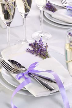 Dining table in Provence style, with Lavender Champagne, folded napkin with cutlery, decorated with fresh lavender. Detail of the wedding dinner. Wedding theme ideas.